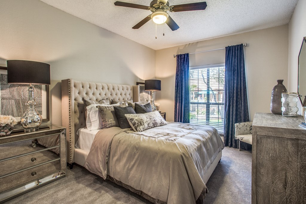 a bedroom with a large bed and a ceiling fan