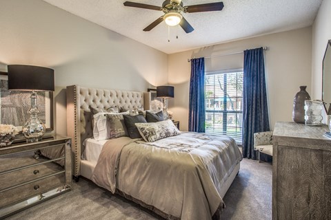 a bedroom with a large bed and a ceiling fan
