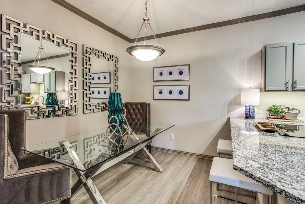 a dining room with a glass table and chairs