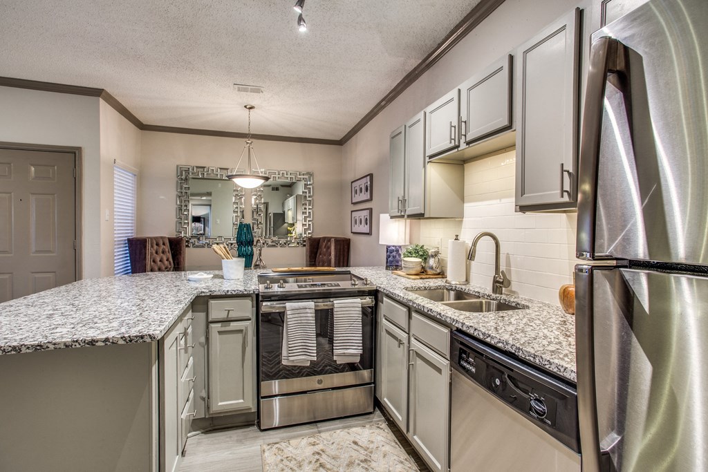an updated kitchen with granite counter tops and stainless steel appliances