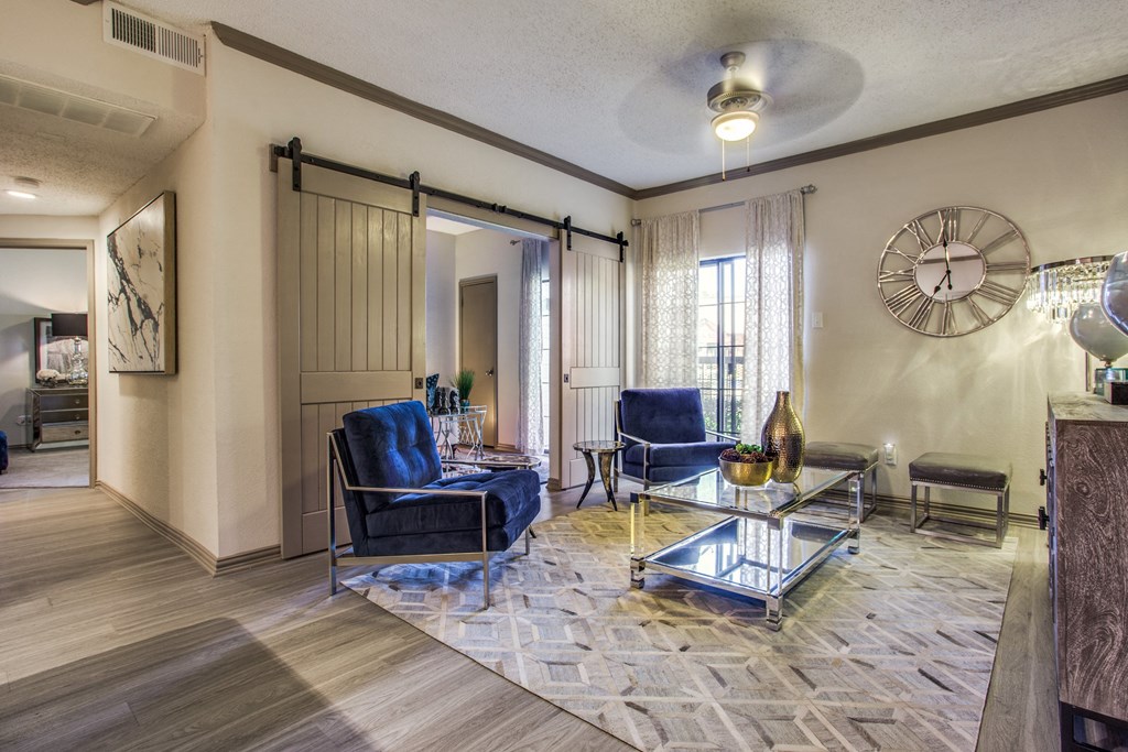 a living room with blue chairs and a clock on the wall