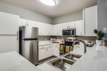 Beautifully appointed interiors with white cabinetry and stainless steel appliances - Photo Gallery 5