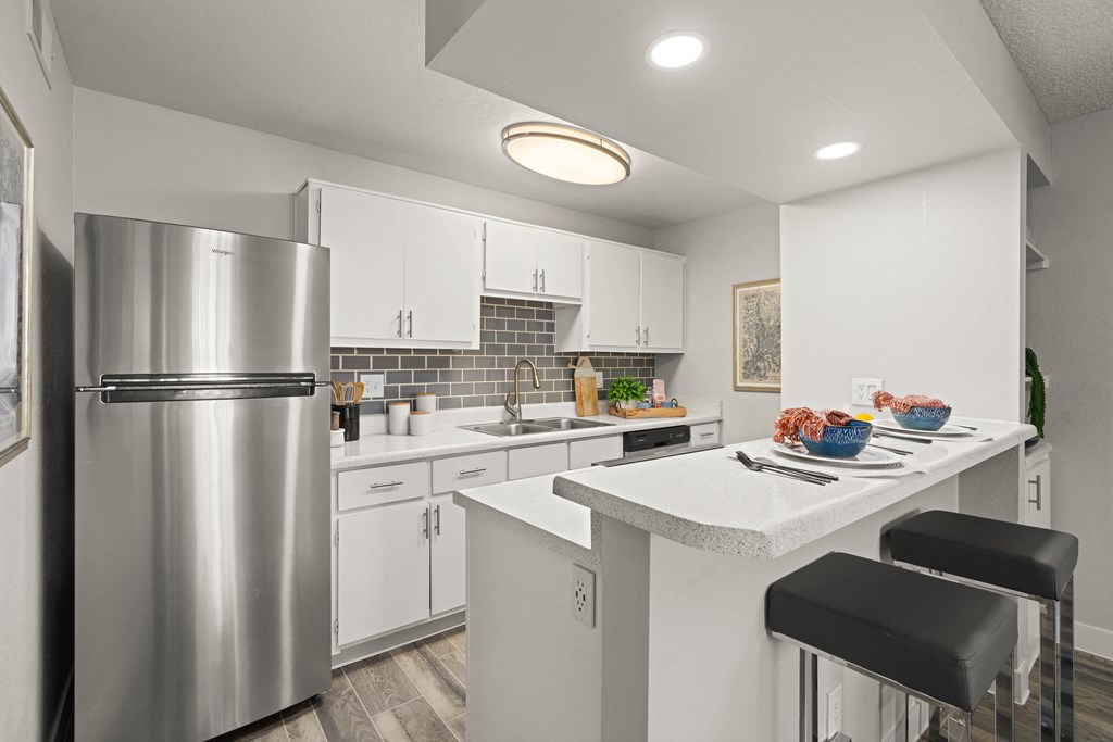 a kitchen with white cabinetry and stainless steel appliances