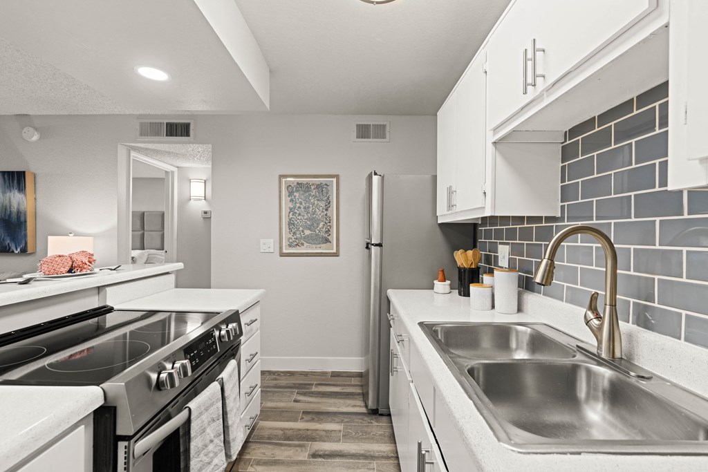 a kitchen with white cabinets and stainless steel appliances
