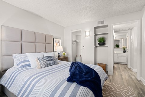 a bedroom with a large bed and a bathroom in the background