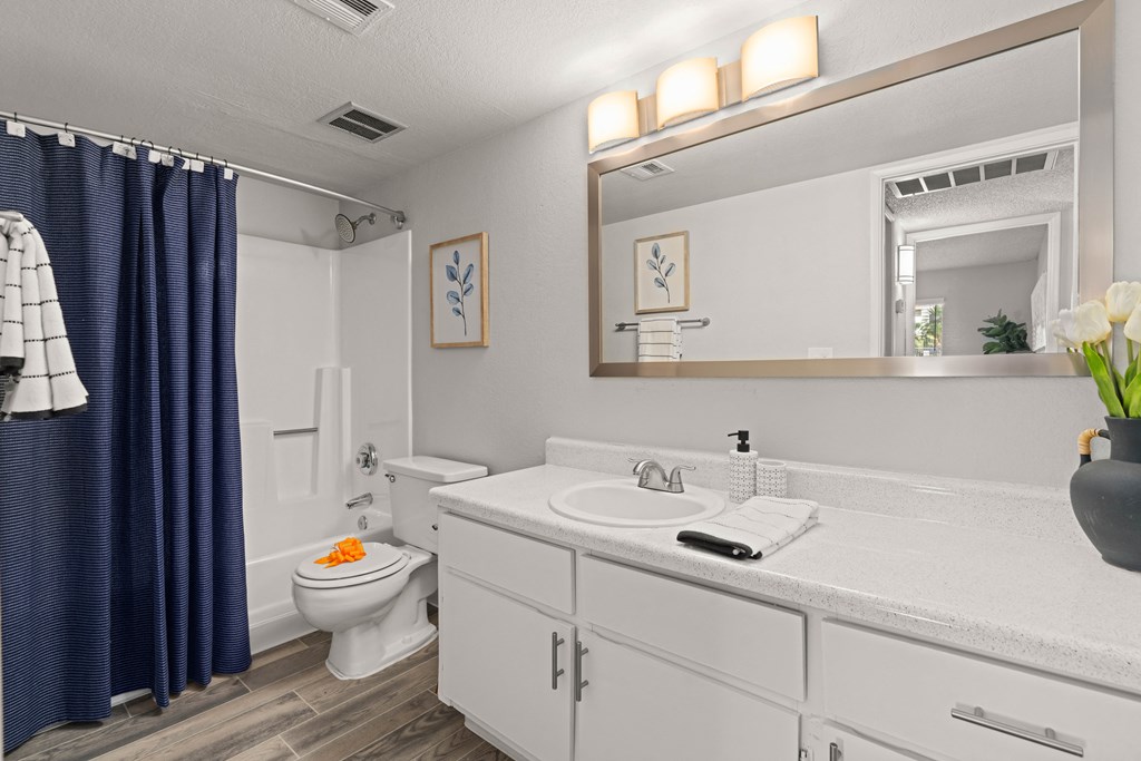 a bathroom with a white toilet and a blue shower curtain