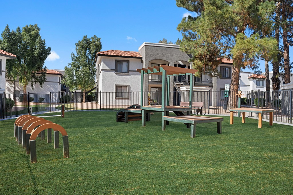 a picnic area with benches and a swing set on a grassy area in front of a