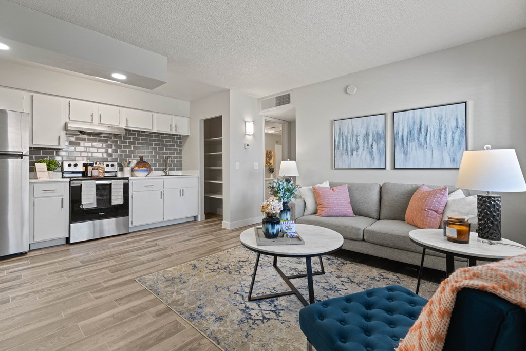our apartments offer a living room with a couch a coffee table and an open kitchen