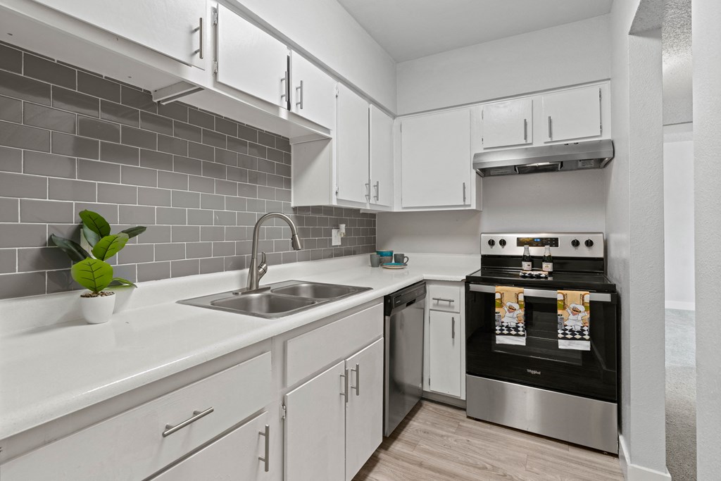 a kitchen with white cabinets and stainless steel appliances