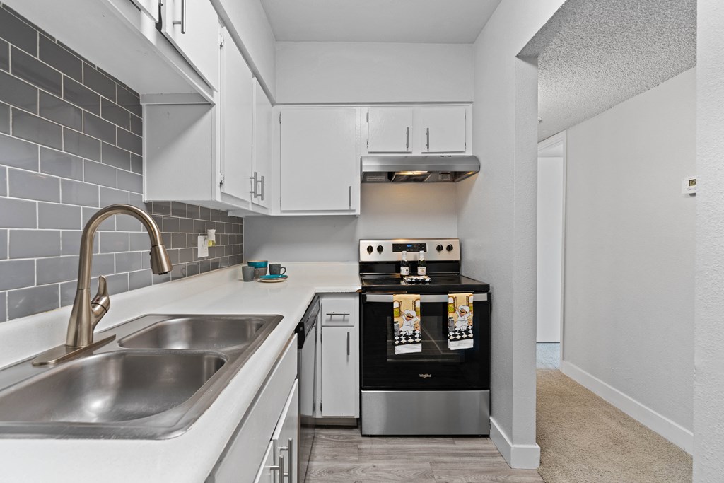 a kitchen with white cabinets and stainless steel appliances