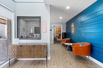 a room with a blue wall and orange chairs - Photo Gallery
