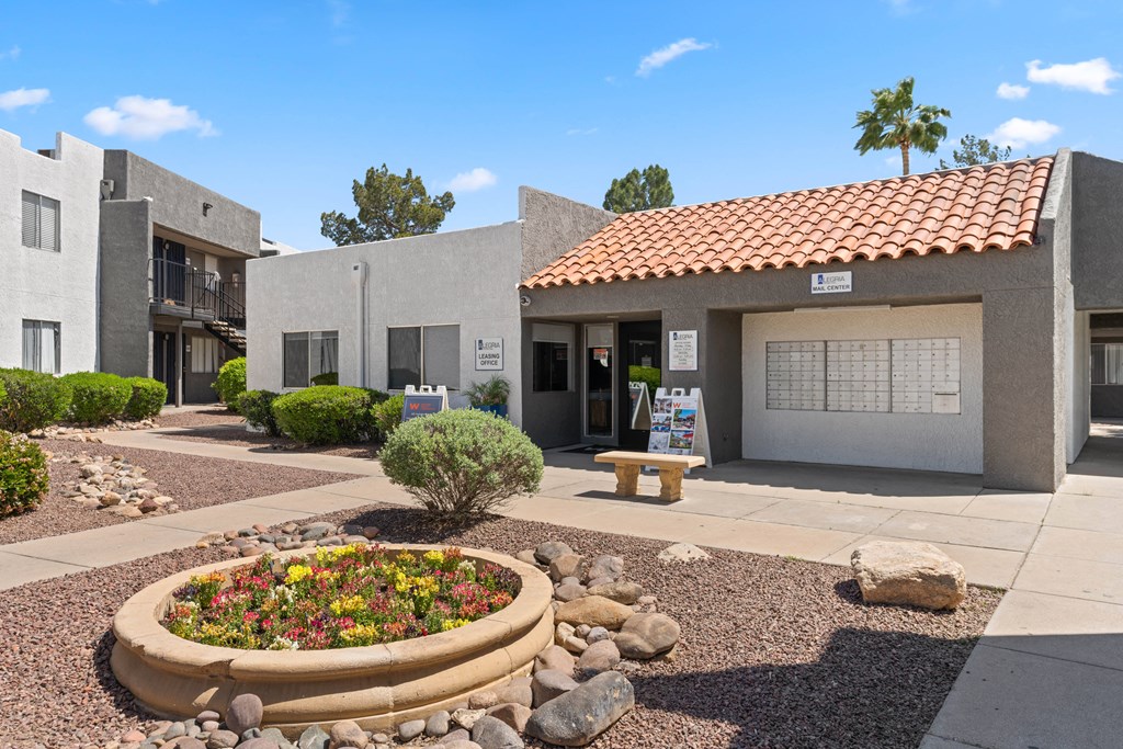 a building with a red tile roof and a white garage door with a bench in front of