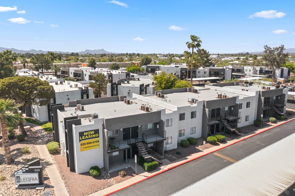 an aerial view of a group of white apartment buildings with a yellow sign on the side of