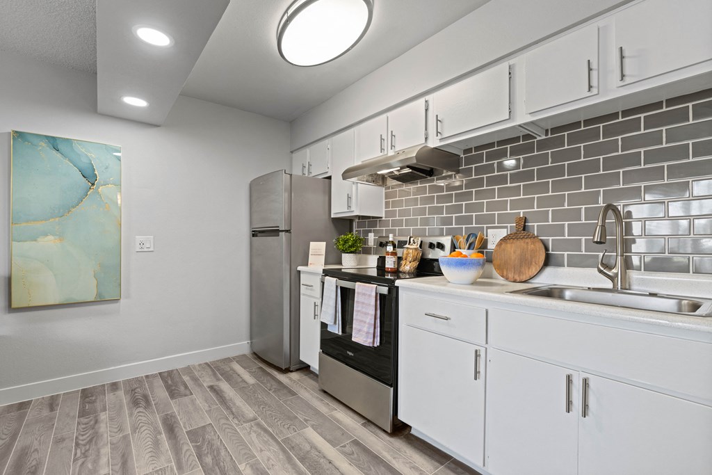 a kitchen with white cabinets and stainless steel appliances