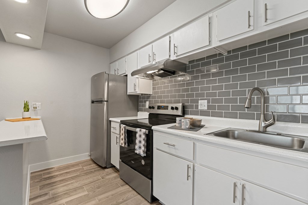 a kitchen with white cabinets and stainless steel appliances