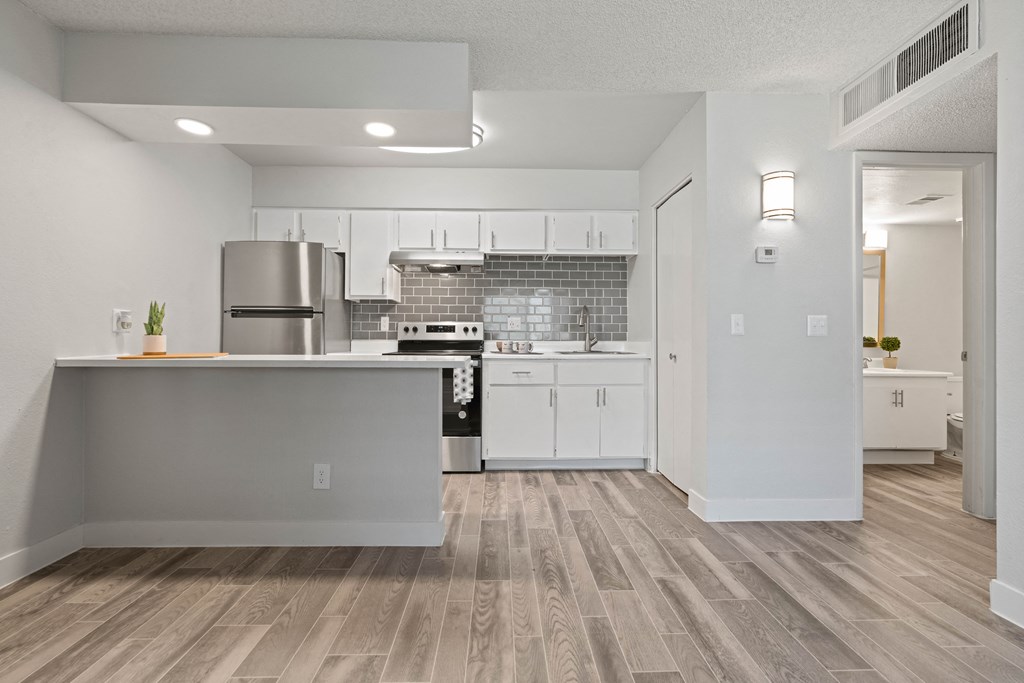 an open kitchen and living room with a hardwood floor