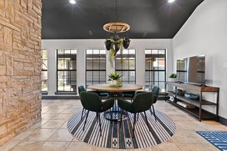 a dining room with a table and chairs and a brick wall