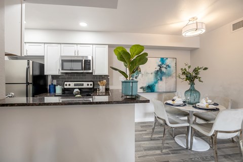 an open kitchen and dining area with a table and chairs