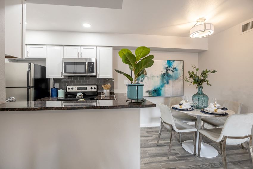 Newly renovated large dining area and kitchen with white cabinets, stainless steel appliances, and breakfast bar - Photo Gallery