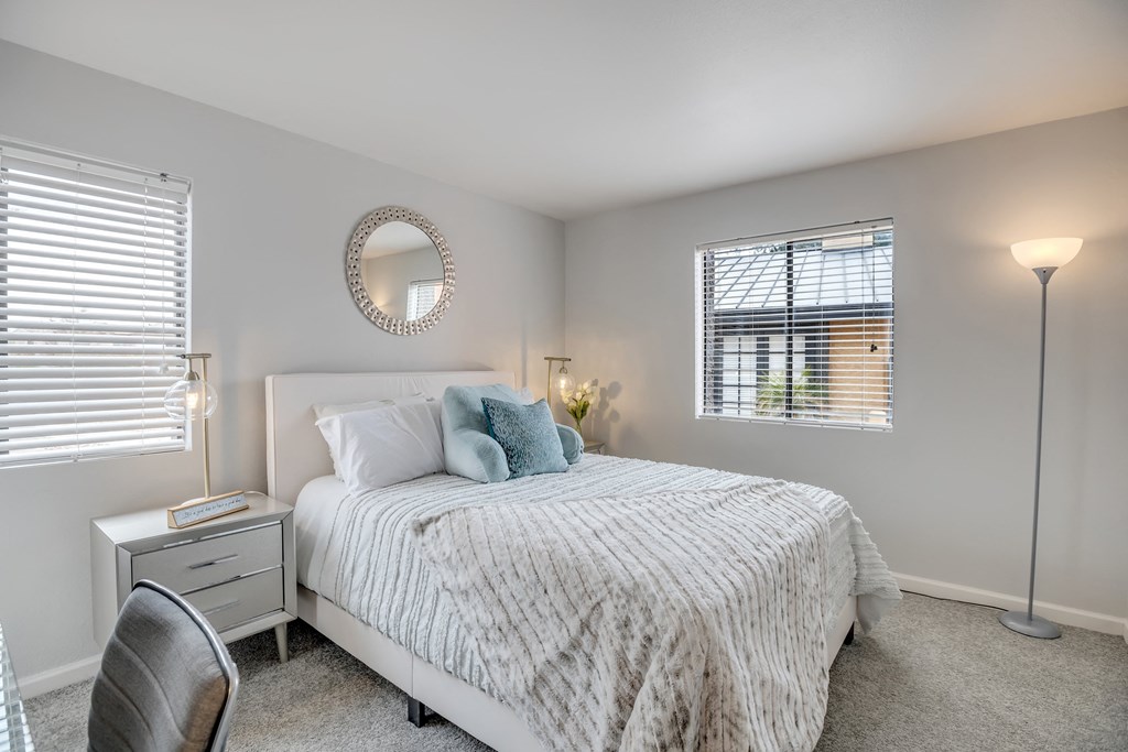Large carpeted bedroom with two windows and walk-in closet in Tempe, AZ