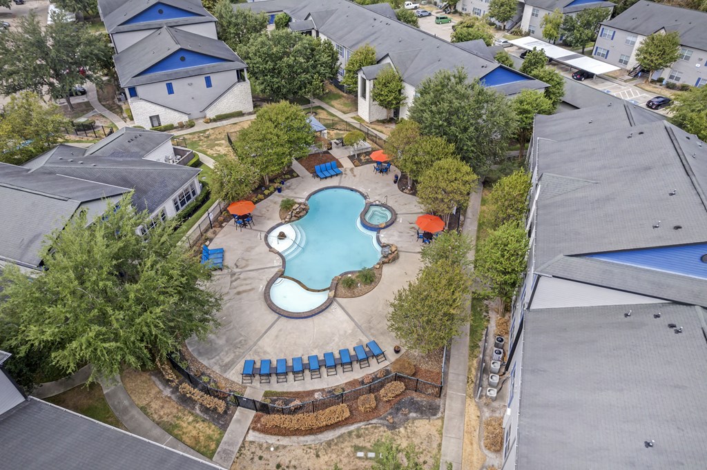 an aerial view of a pool in the backyard of a house
