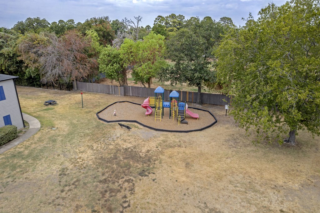 a playground is shown in a backyard with trees