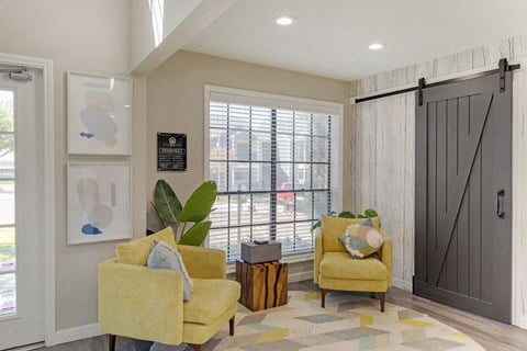 a living room with two yellow chairs and a barn door