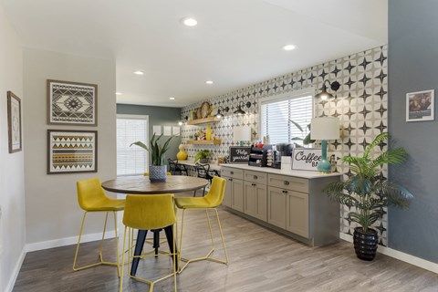 a kitchen and dining area with yellow chairs and a counter
