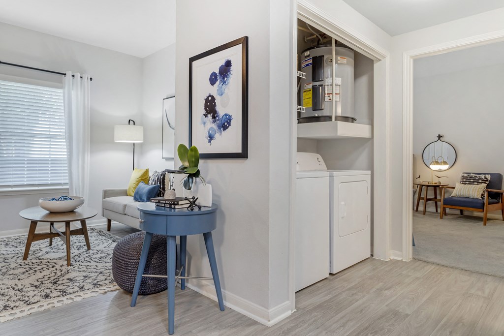 a living room with a blue table and a kitchen in the background