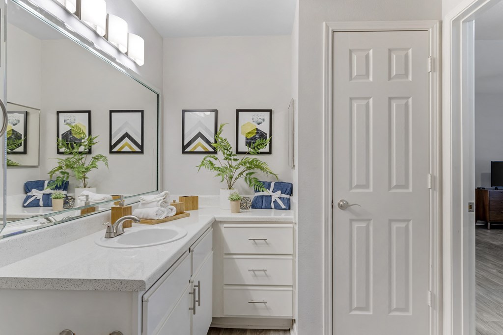 a white bathroom with a sink and a mirror