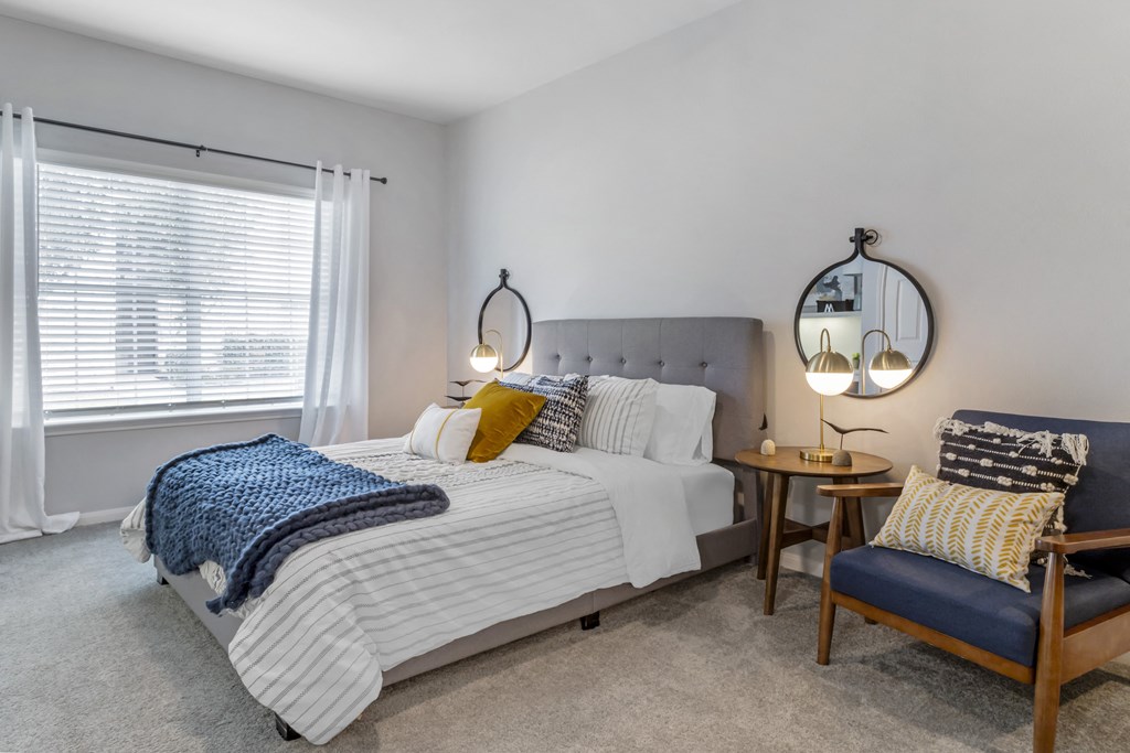 a bedroom with a bed and a chair and a table