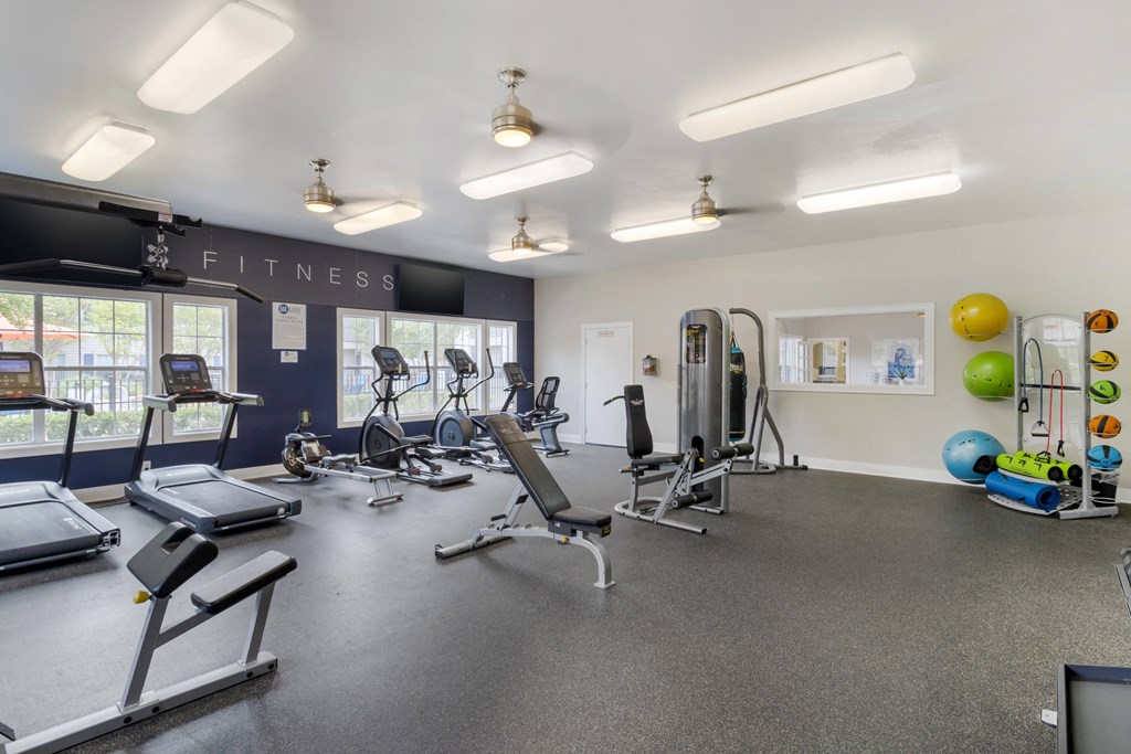 a gym with cardio equipment and weights in a fitness center