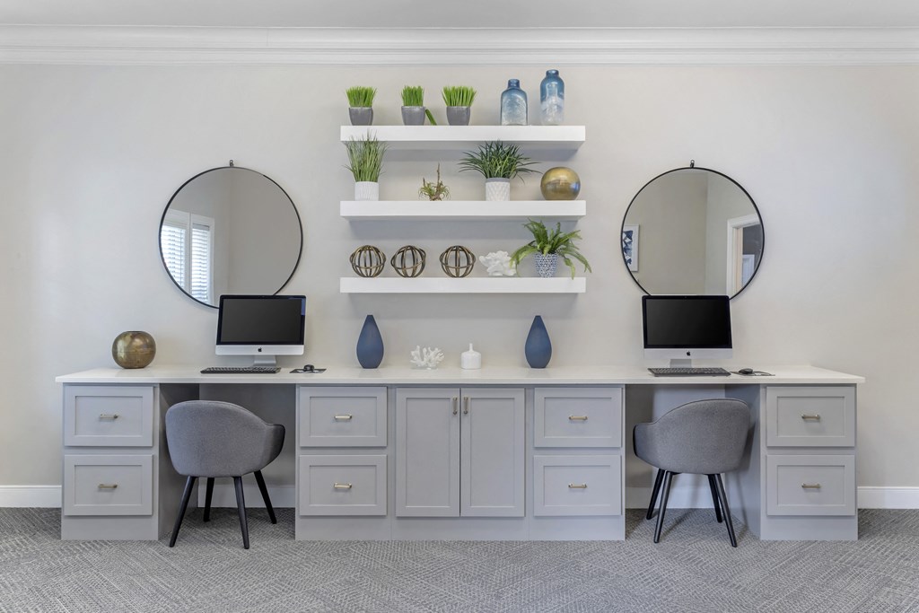 a dressing room with two mirrors and two desks and two chairs