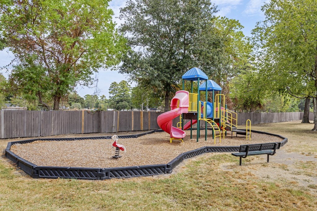 a playground with a slide and a duck in a park