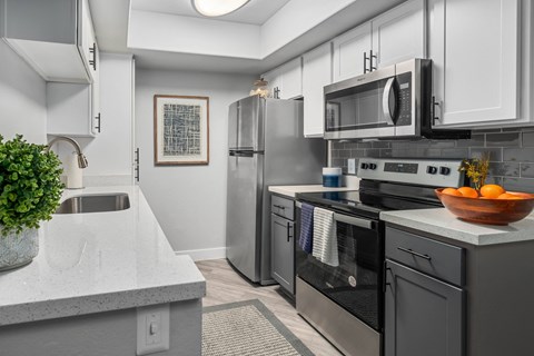 a kitchen with stainless steel appliances and white counter tops