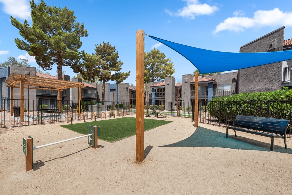 a blue awning hangs over a park bench in front of apartment buildings