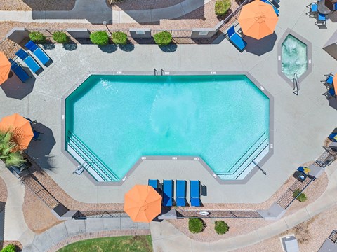 an aerial view of a swimming pool with umbrellas and chairs