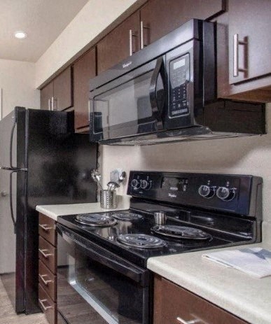 a kitchen with a stove and a microwave and a refrigerator