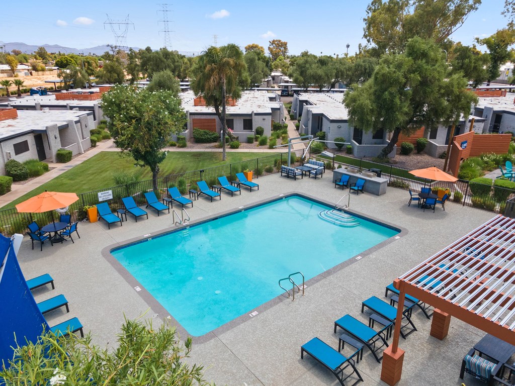 an aerial view of the resort style pool with chaise lounge chairs and umbrellas