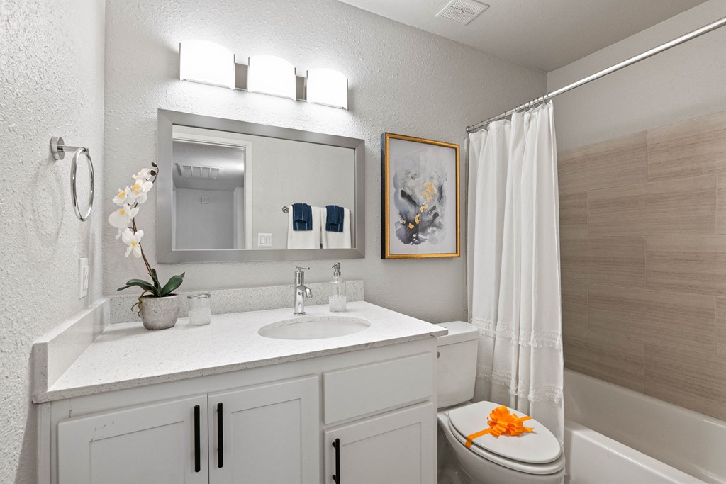 a bathroom with white cabinets and a white shower curtain