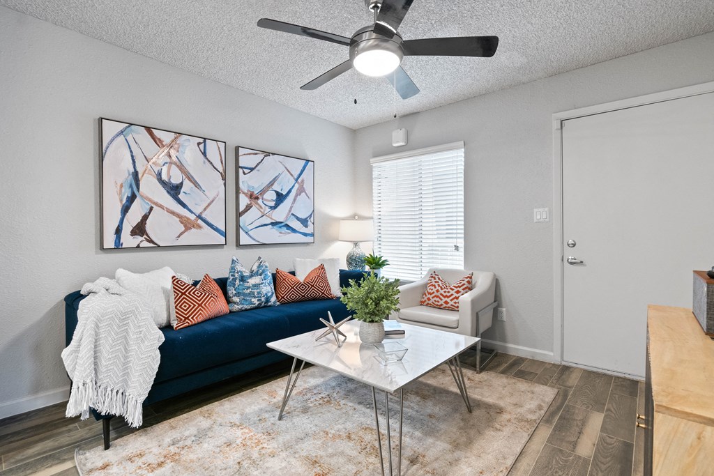 a living room with a blue couch and a white coffee table