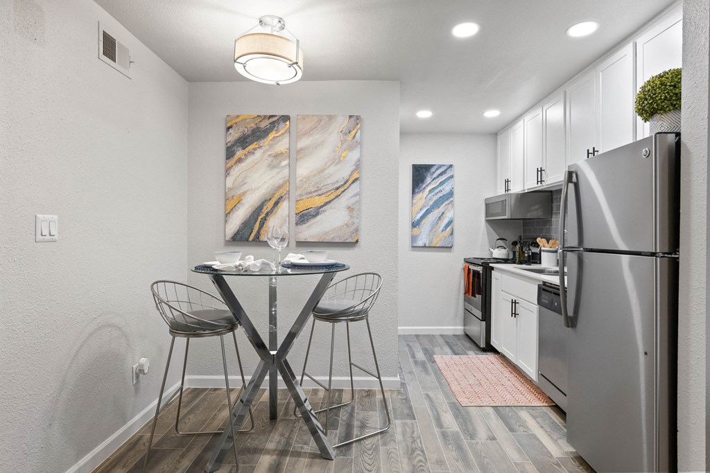 a kitchen with white cabinetry and stainless steel appliances