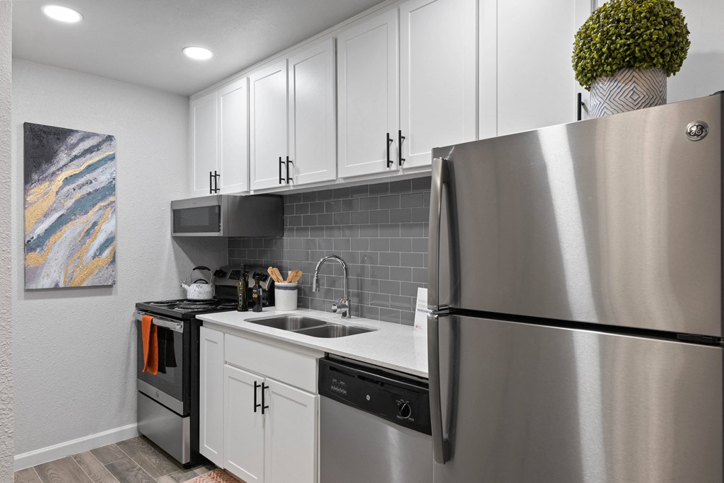 a kitchen with white cabinets and stainless steel appliances