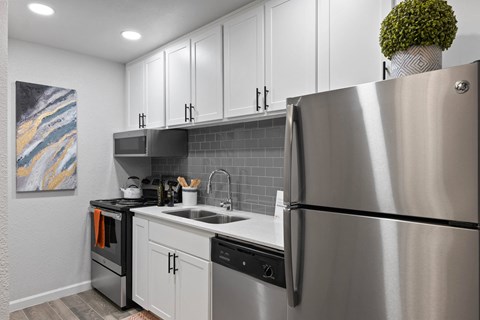 a kitchen with stainless steel appliances and white cabinets