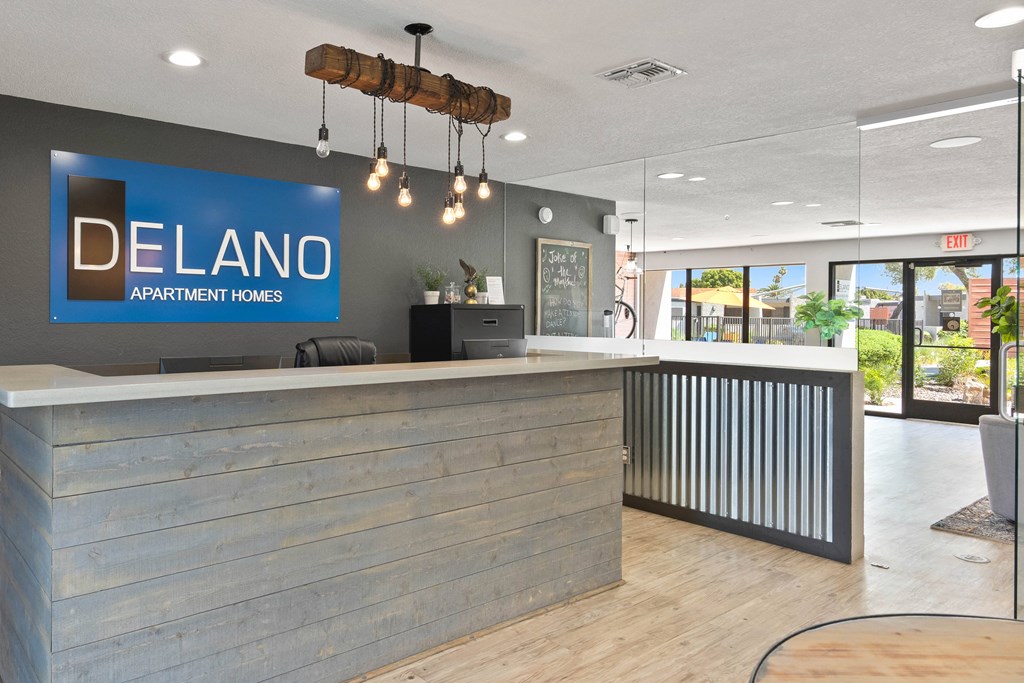 a reception desk with a blue sign that says delano apartments