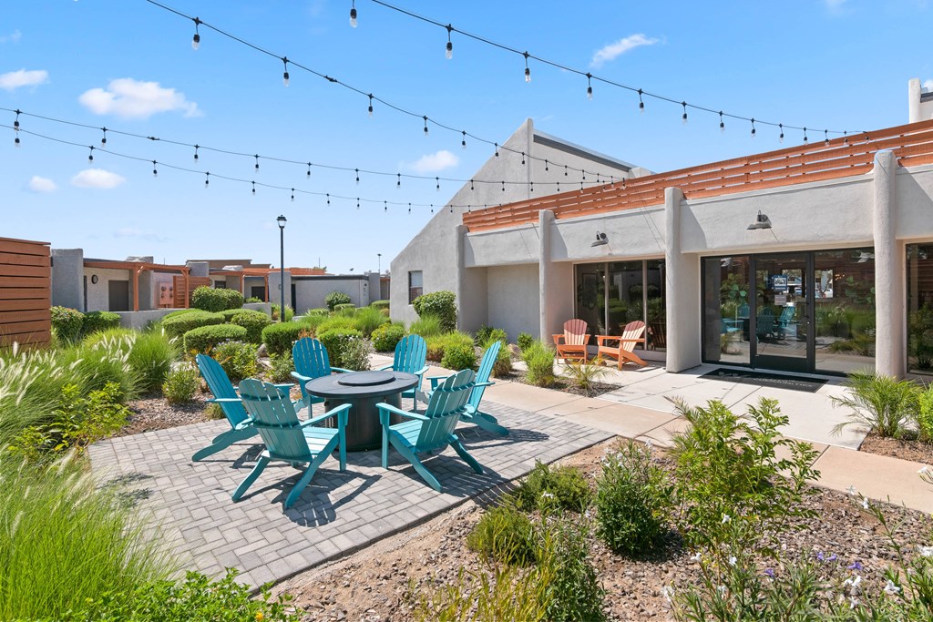 a patio with a table and chairs and a building in the background