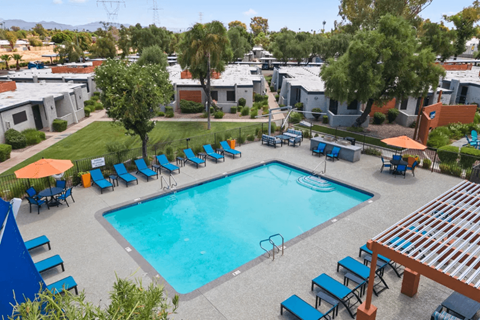 A swimming pool surrounded by blue lounge chairs and umbrellas.