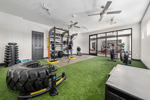 a home gym with a large tire in the middle of the room
