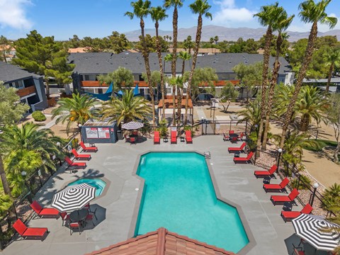 an aerial view of the resort style pool with lounge chairs and umbrellas