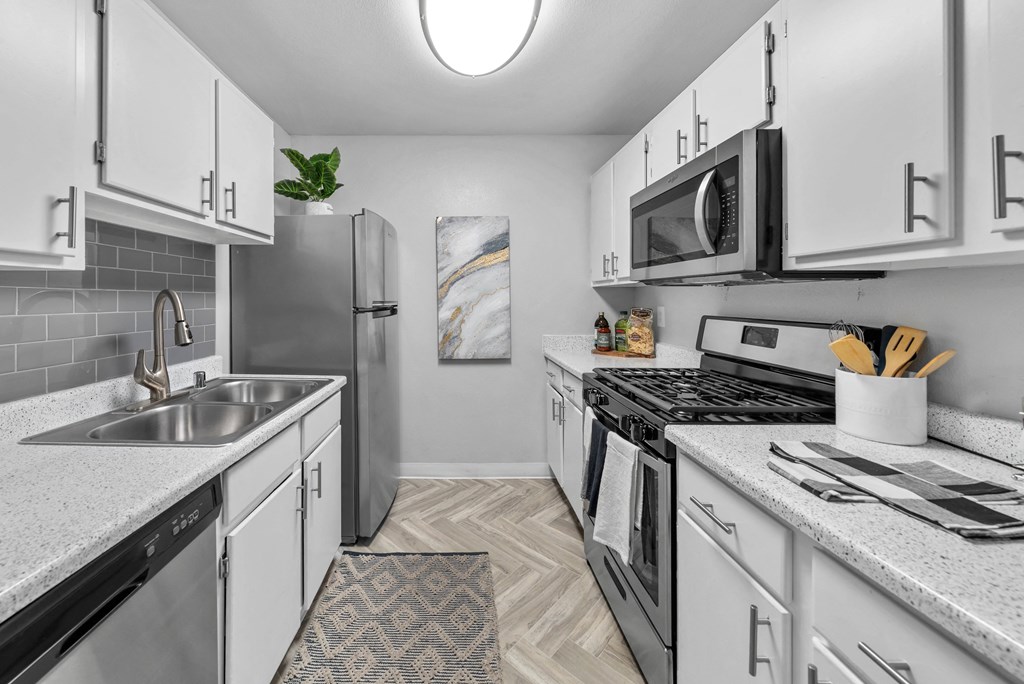 a kitchen with white cabinetry and stainless steel appliances